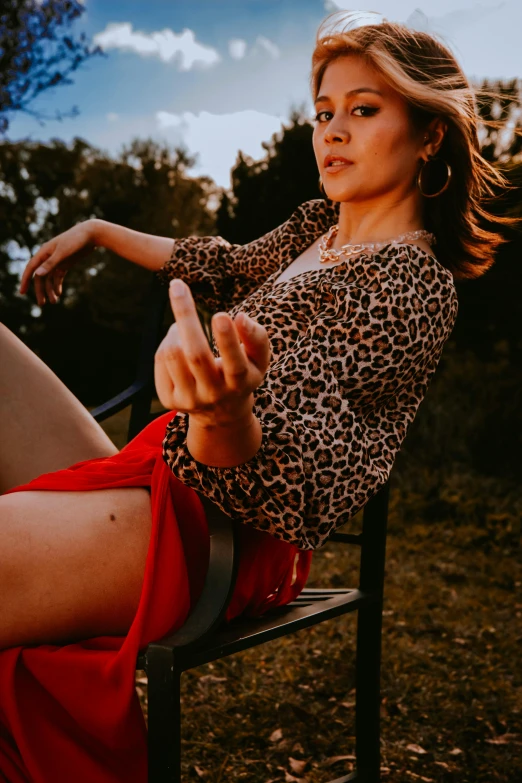 a woman is sitting on a chair pointing a finger