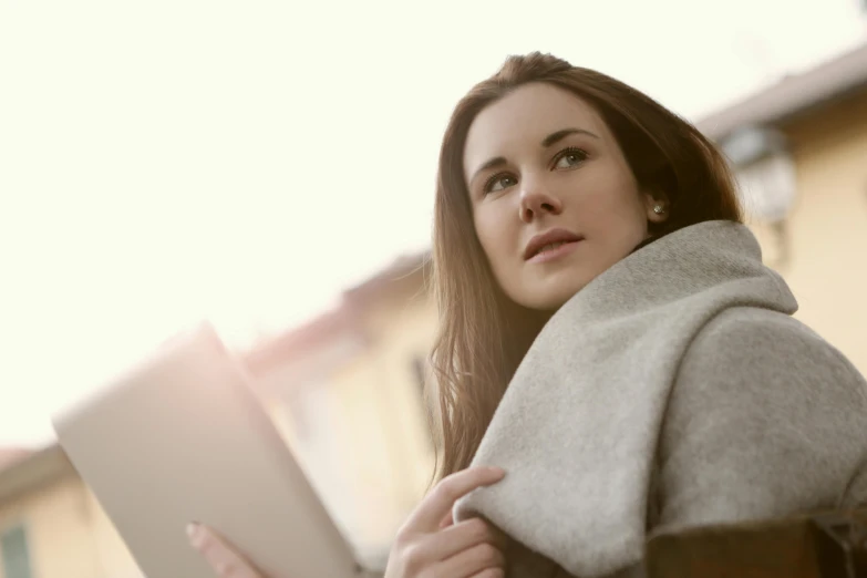 a young lady looks at her tablet outdoors