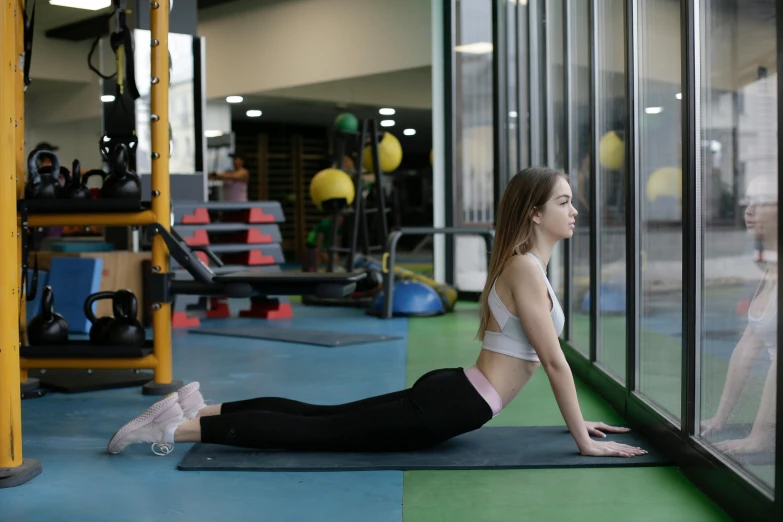 a young woman is doing exercise in a gym