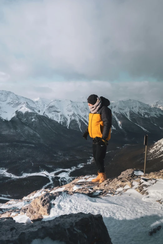 the man is on the mountain looking out over the valley