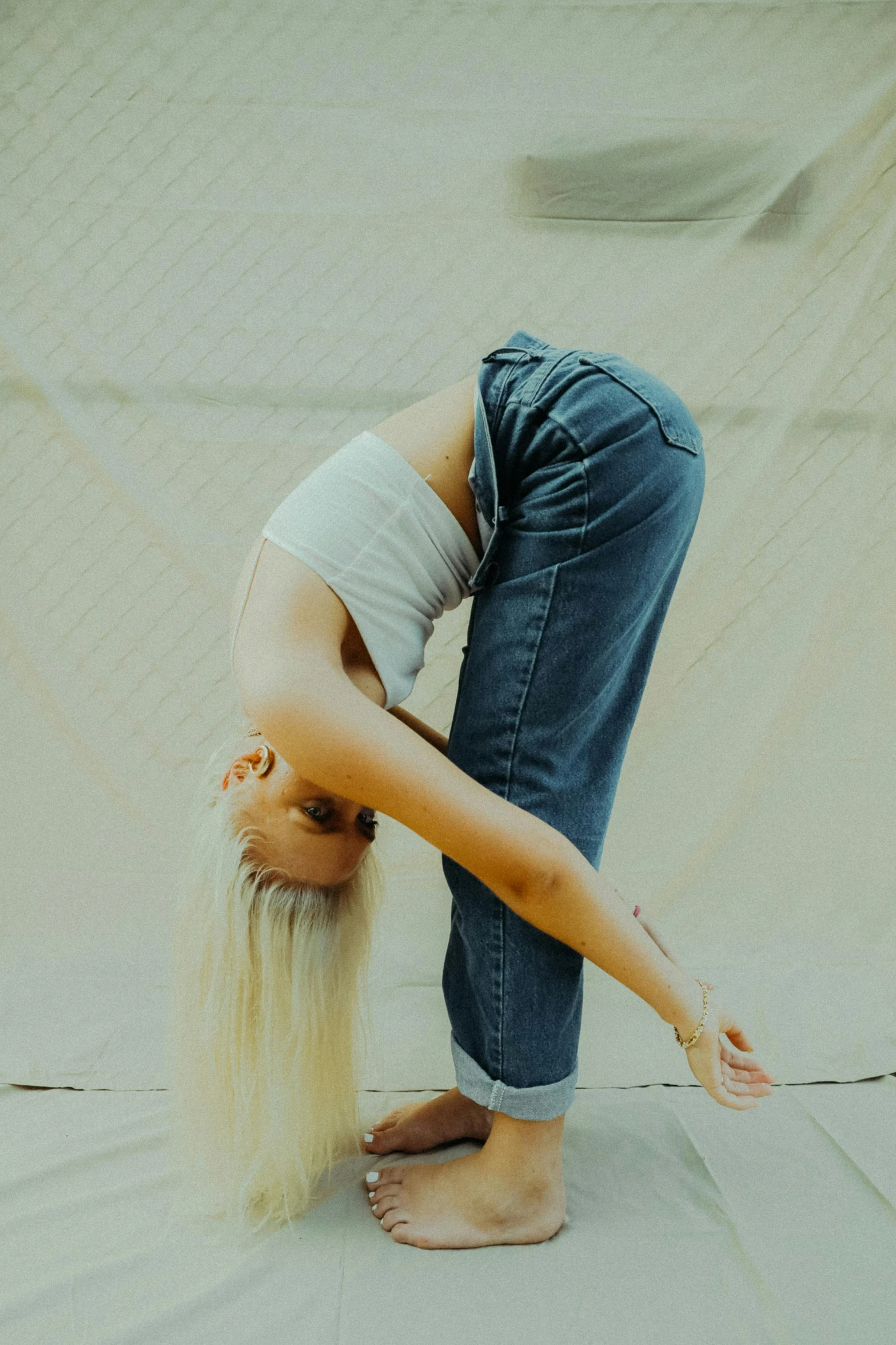 a woman standing on one leg while bent over in the ground