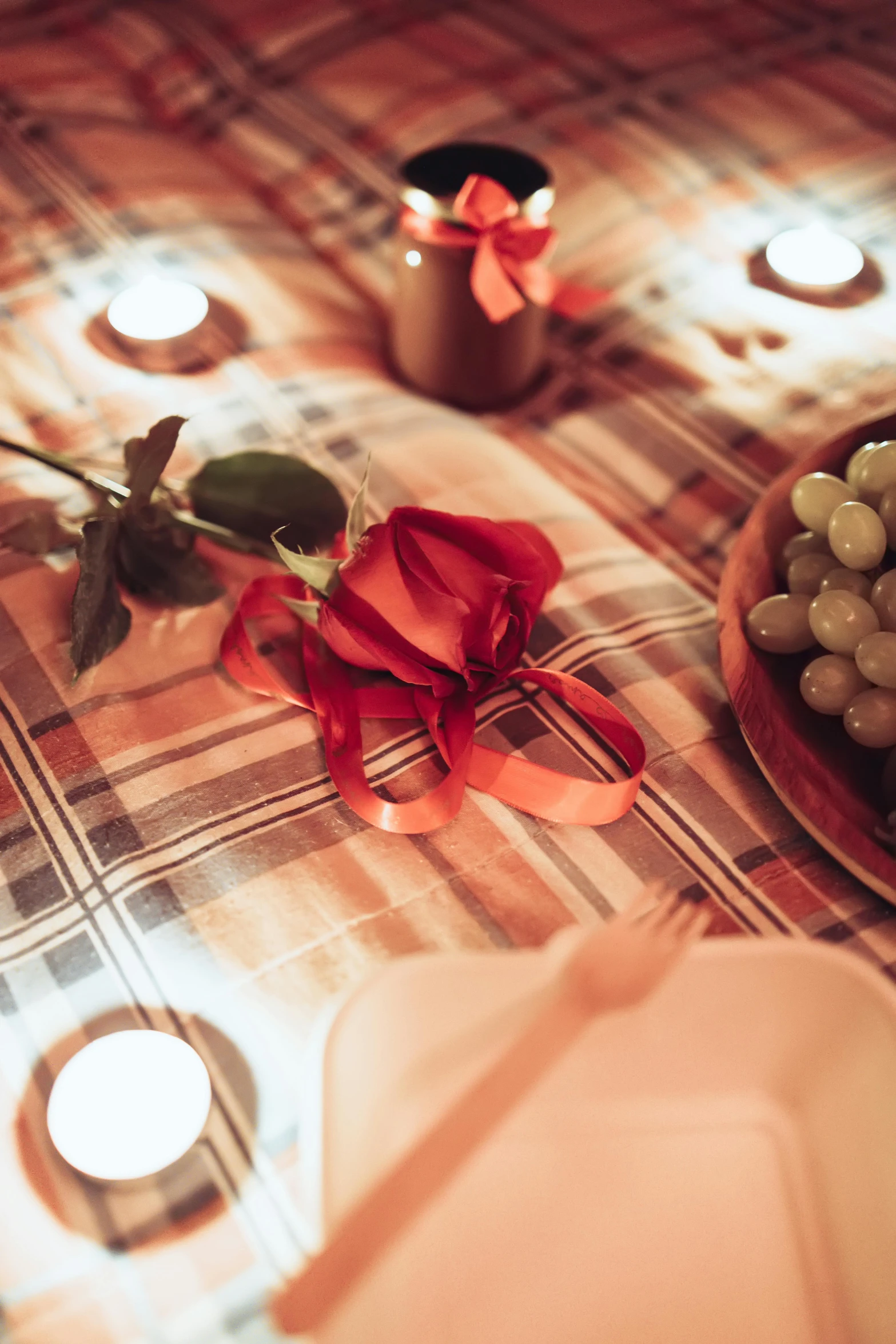 two plates with roses on a table with candles