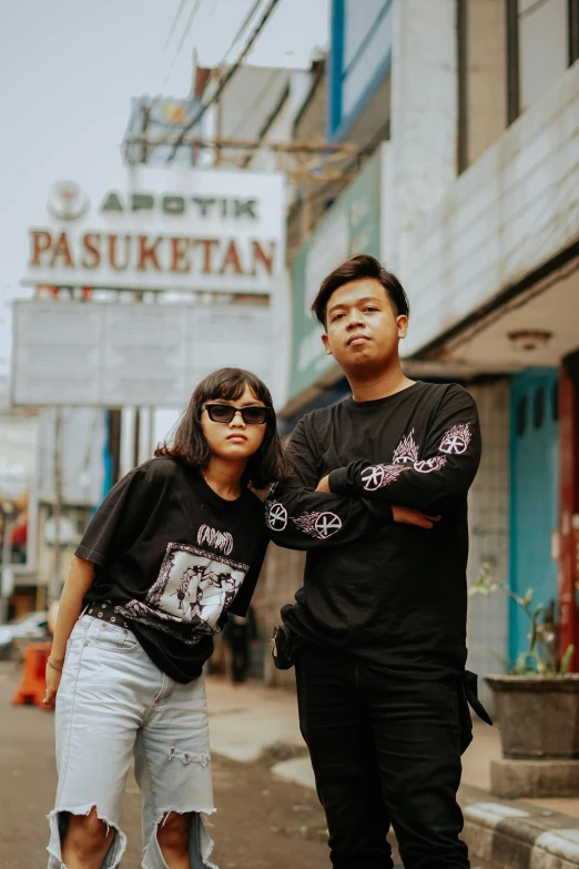 two asian people with sunglasses standing in the street