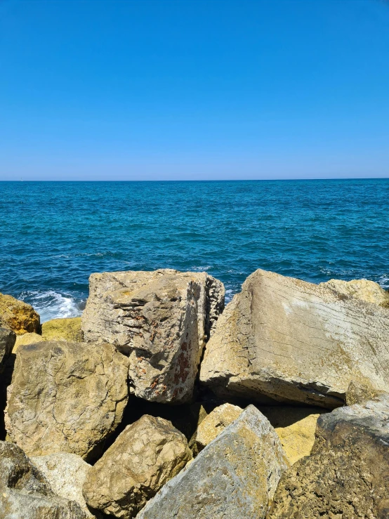 several large rocks along the edge of the water