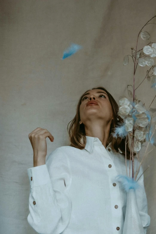 woman in white shirt with flowers blowing from back