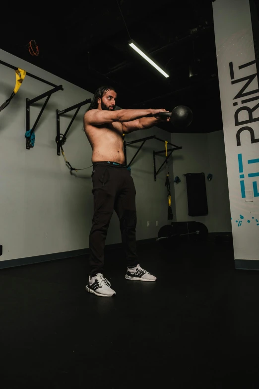 a man in a garage lifting up his arm and a kettle