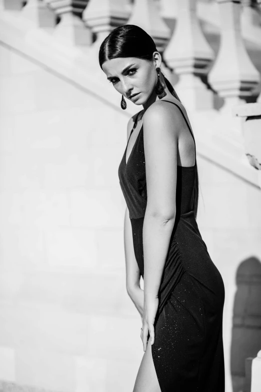 a young woman is standing on the stairs outside