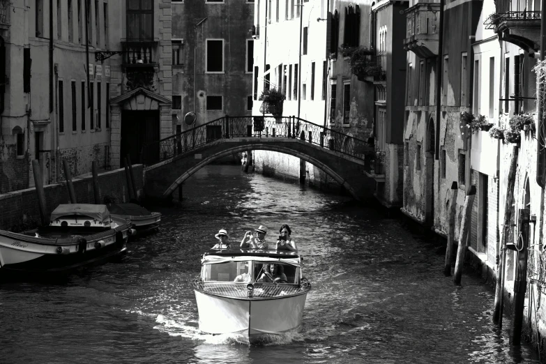 a white boat traveling down a river next to a bridge