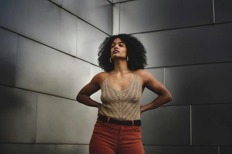 a woman in red pants stands on an industrial wall