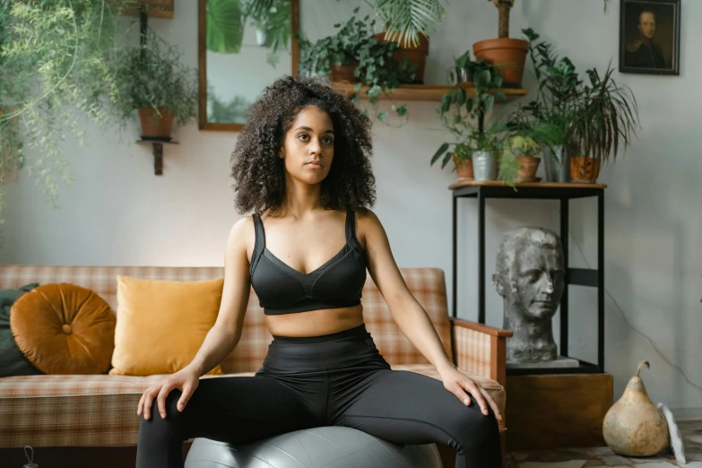 a beautiful woman sitting on top of an inflatable ball