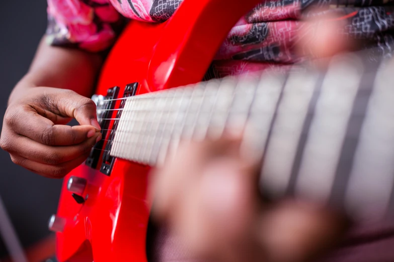 someone playing on an electric guitar with an orange pick