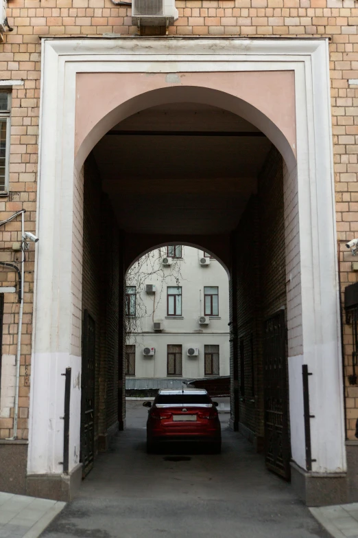 an suv parked under a large stone arch