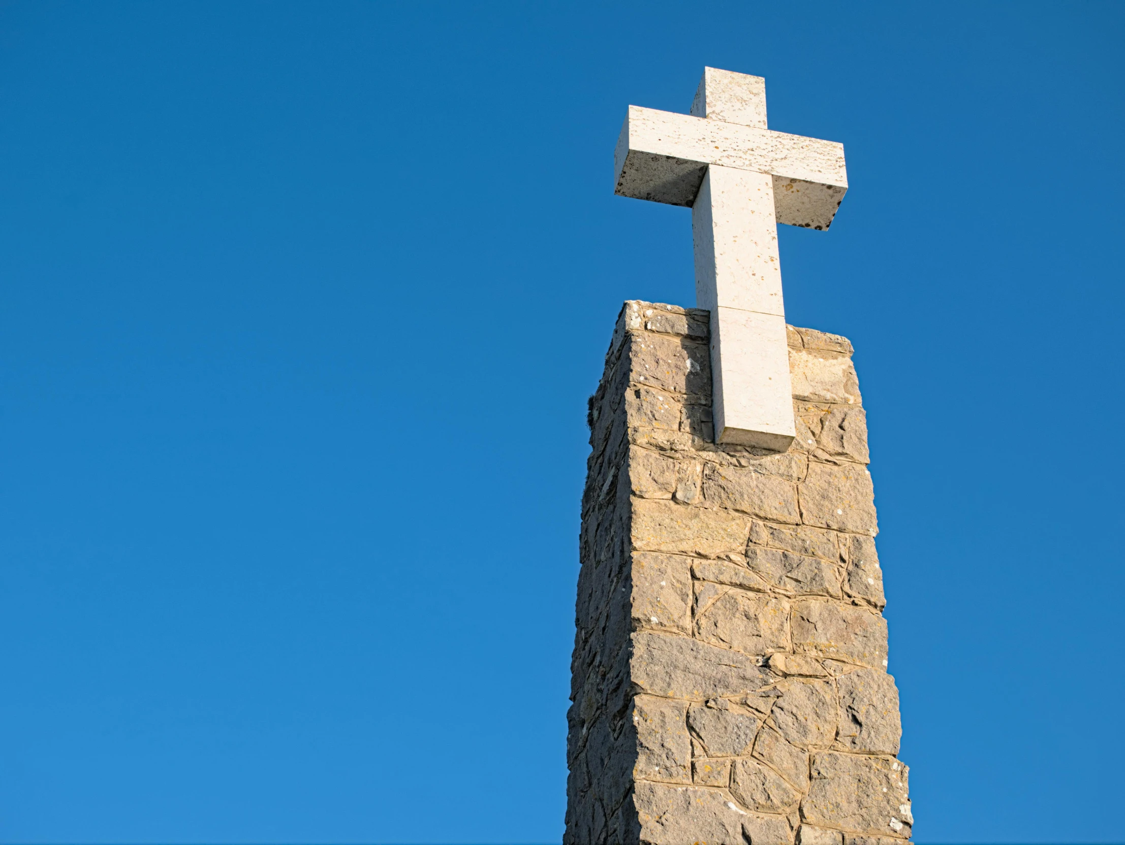 a cross is sitting on a stone structure