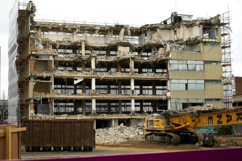 the demolition of an old building in london, with the crane attached