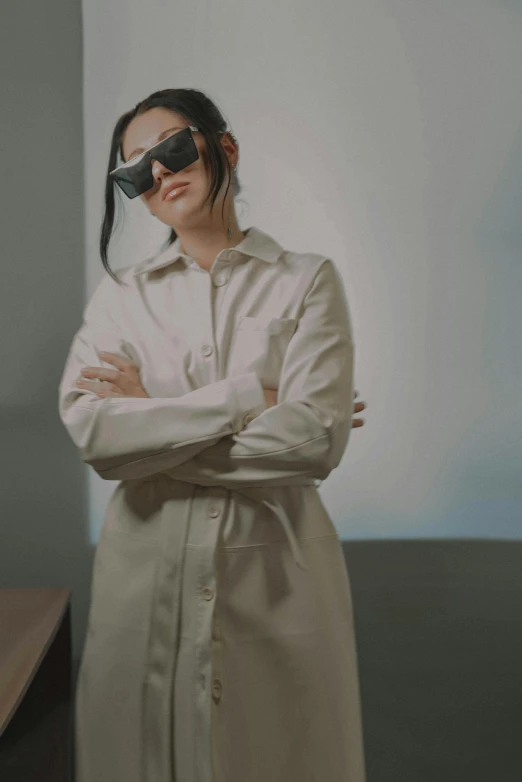 a woman is wearing sunglasses with her arms crossed