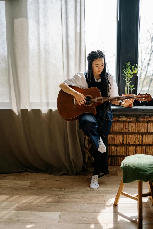 a person holding a guitar near a desk