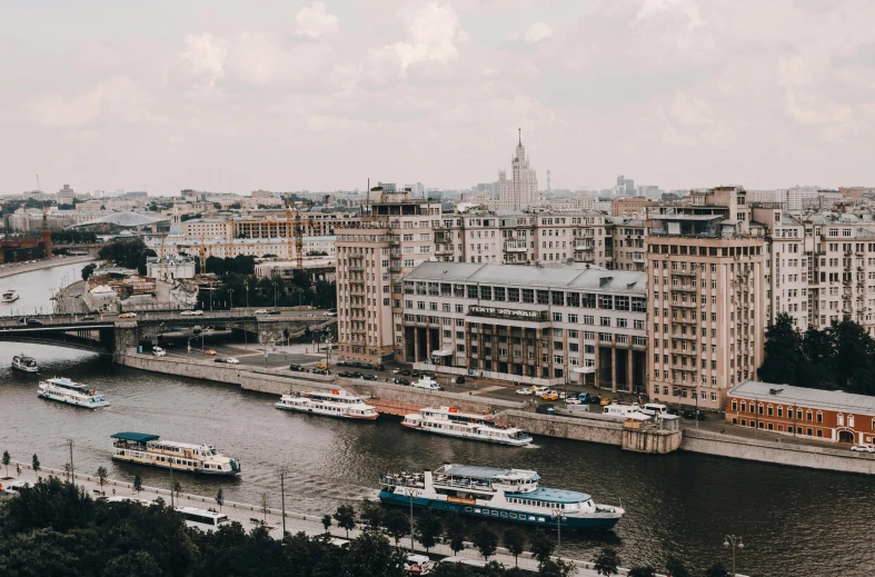 several boats parked on the water near many tall buildings