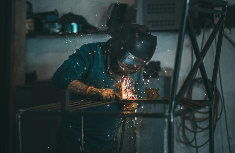 there is a male in a blue shirt using a grinding mill