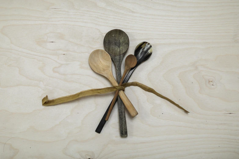 a wooden surface with spoons and some other things