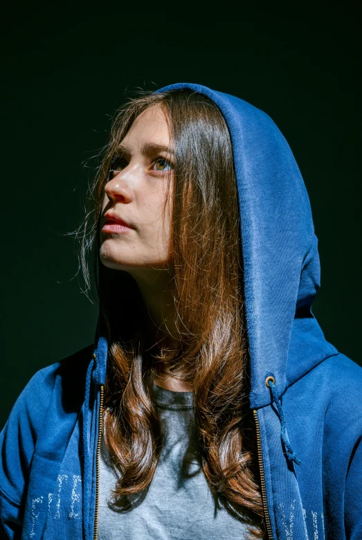 a woman wearing a hoodie and looking down