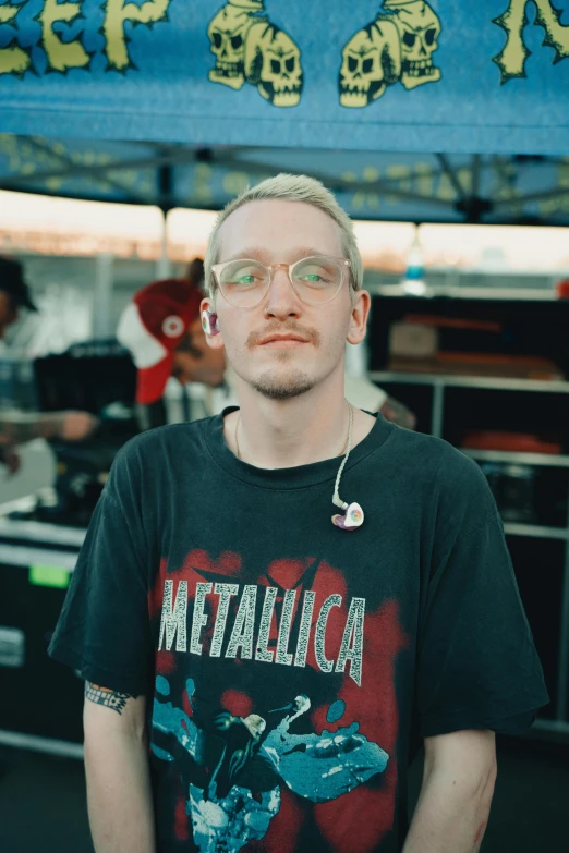 man with glasses on standing in front of a tent