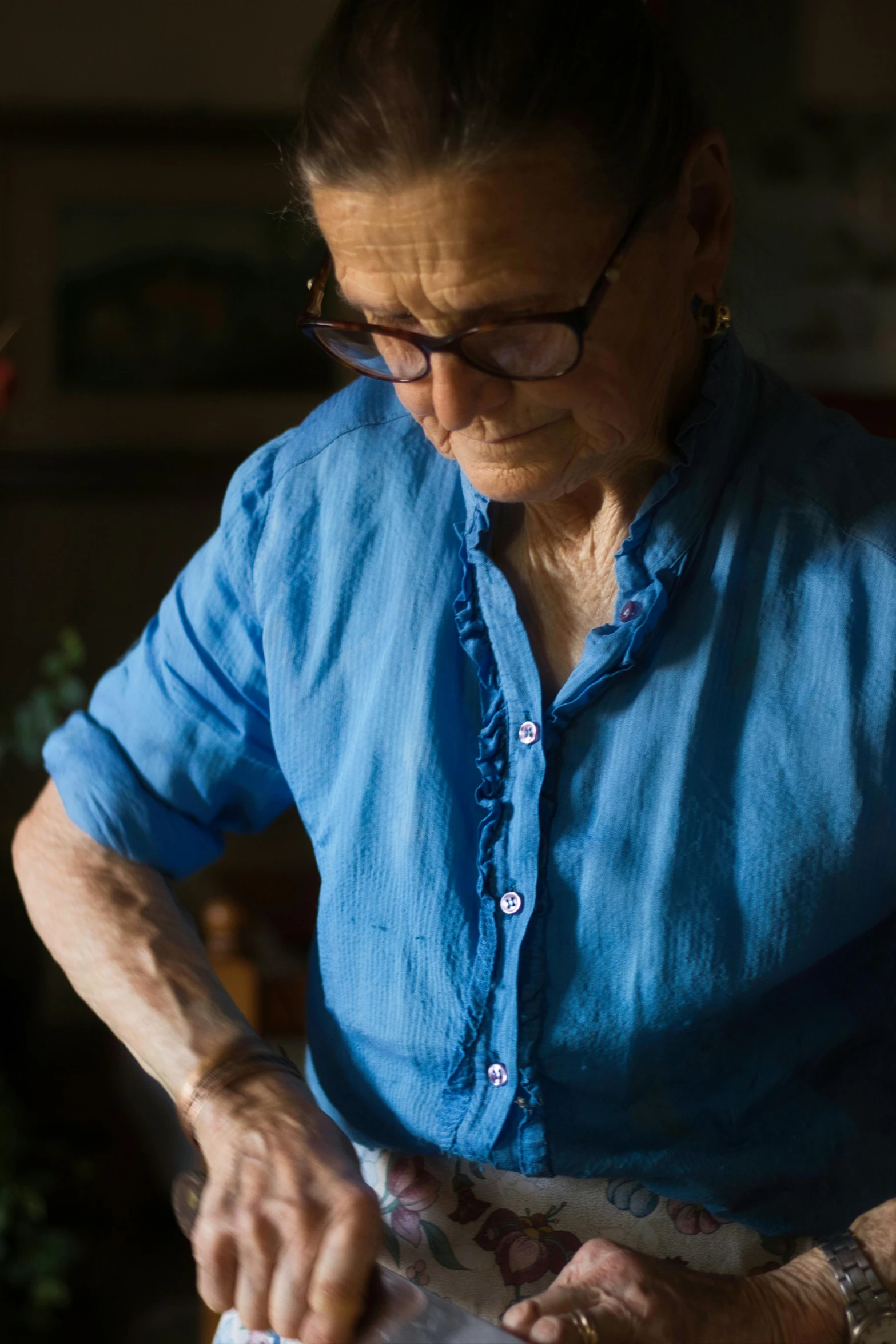 a woman in a blue shirt  bread on a table