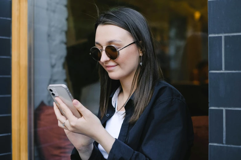 the woman in sunglasses is looking at her cellphone