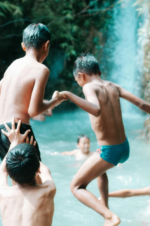 a group of boys in swim trunks playing around