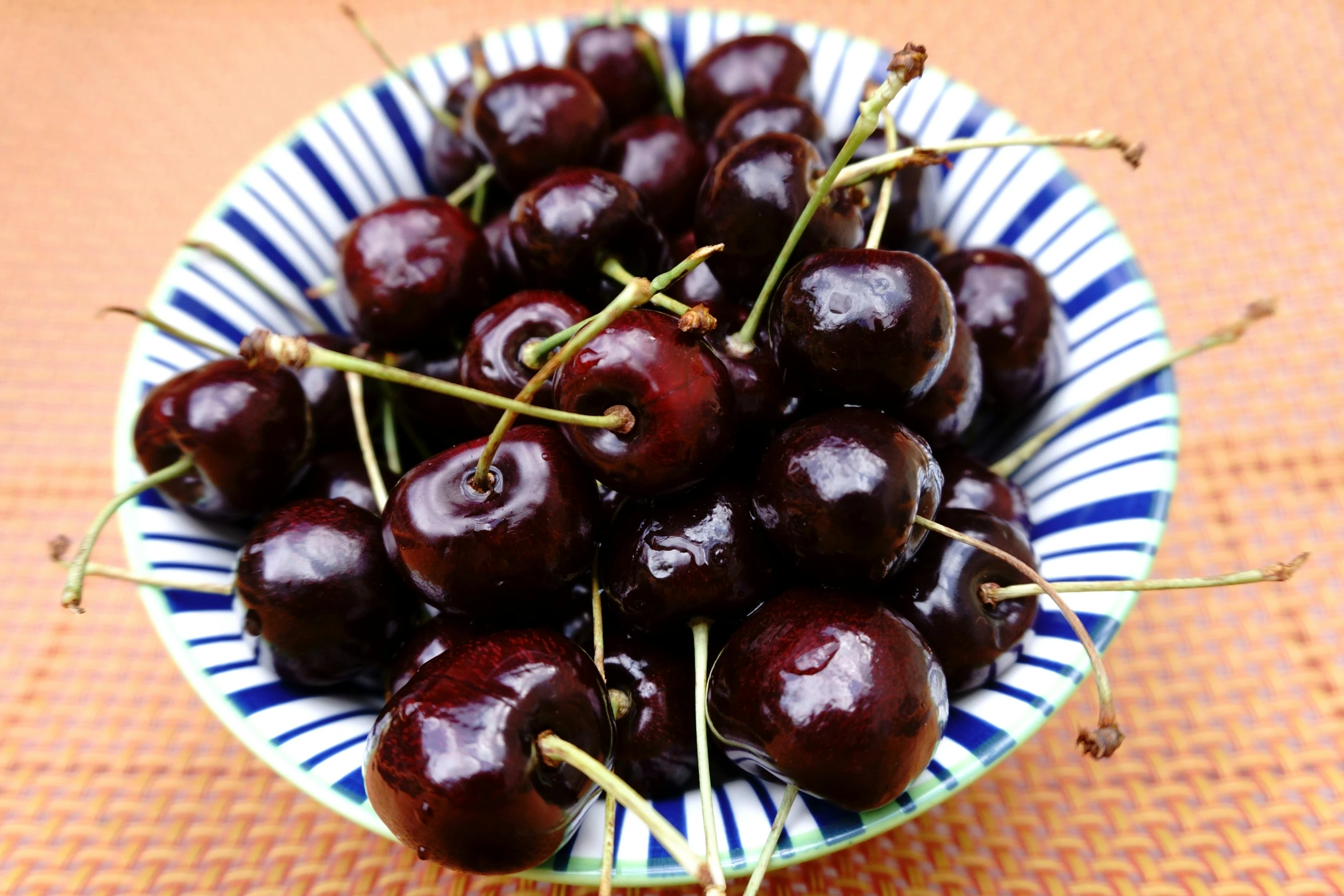 a bowl filled with cherries on a table