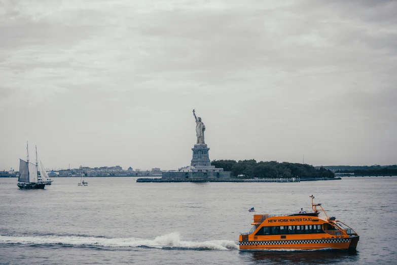 a small boat riding on the water near statue