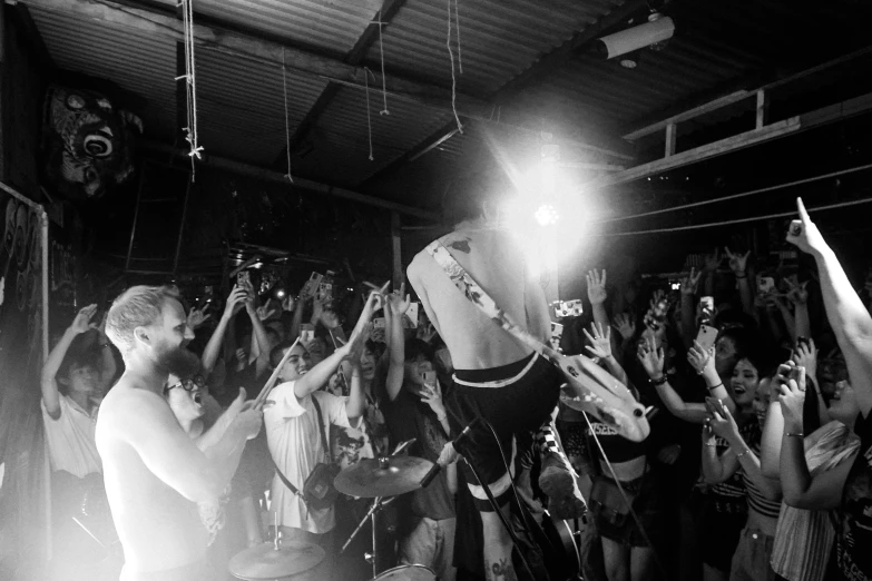 a crowd is gathered around a band playing together