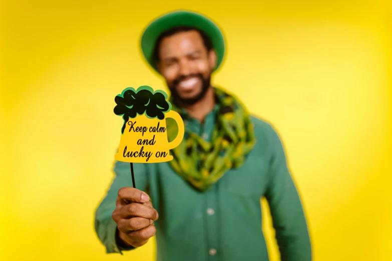 a man wearing a green shirt and scarf holding a stick