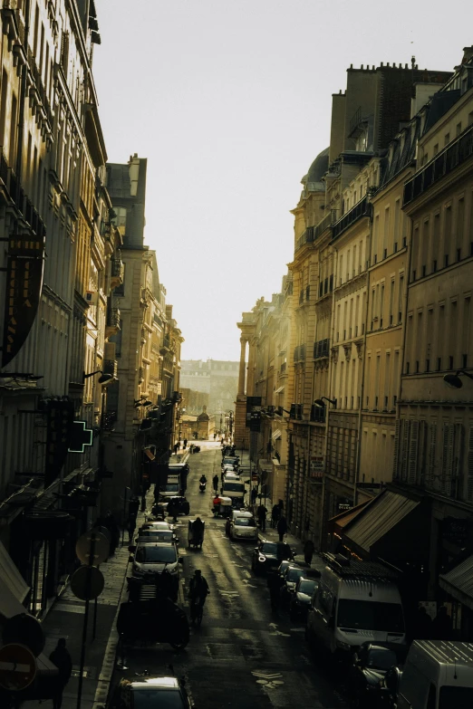 the street is lined with parked cars in paris