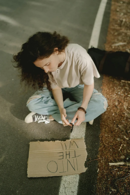 a woman sitting on the side of the road