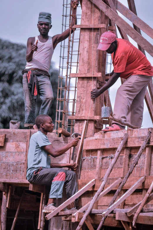 men working on a construction site in front of some trees