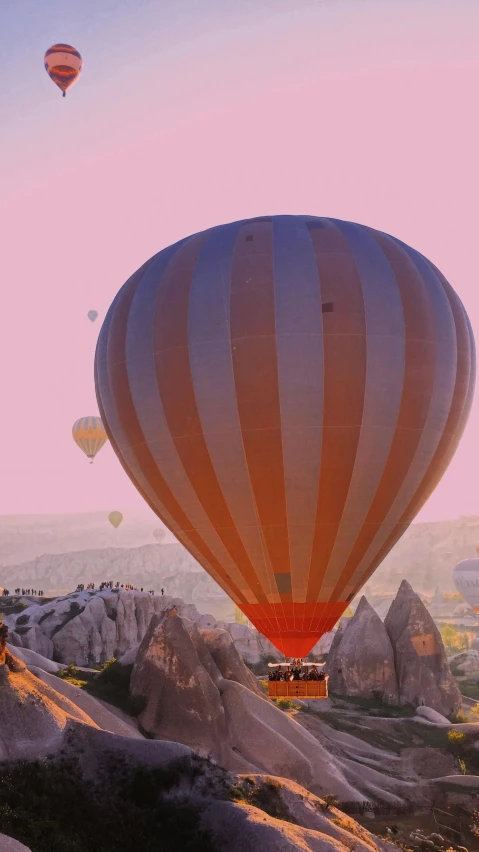 many  air balloons are flying over some rock formations