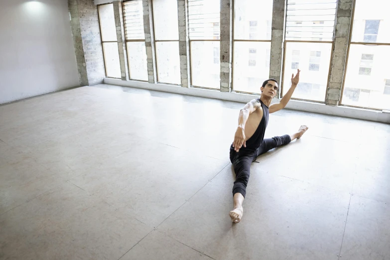 a young man doing the splits on the floor