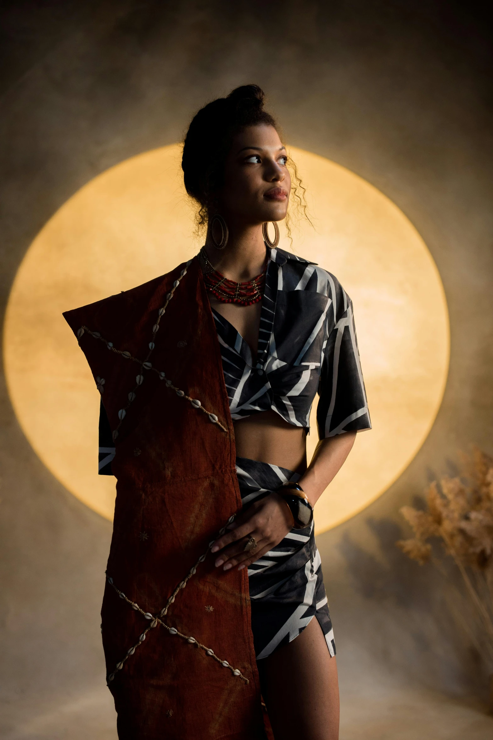 woman in tribal attire standing with full moon backdrop