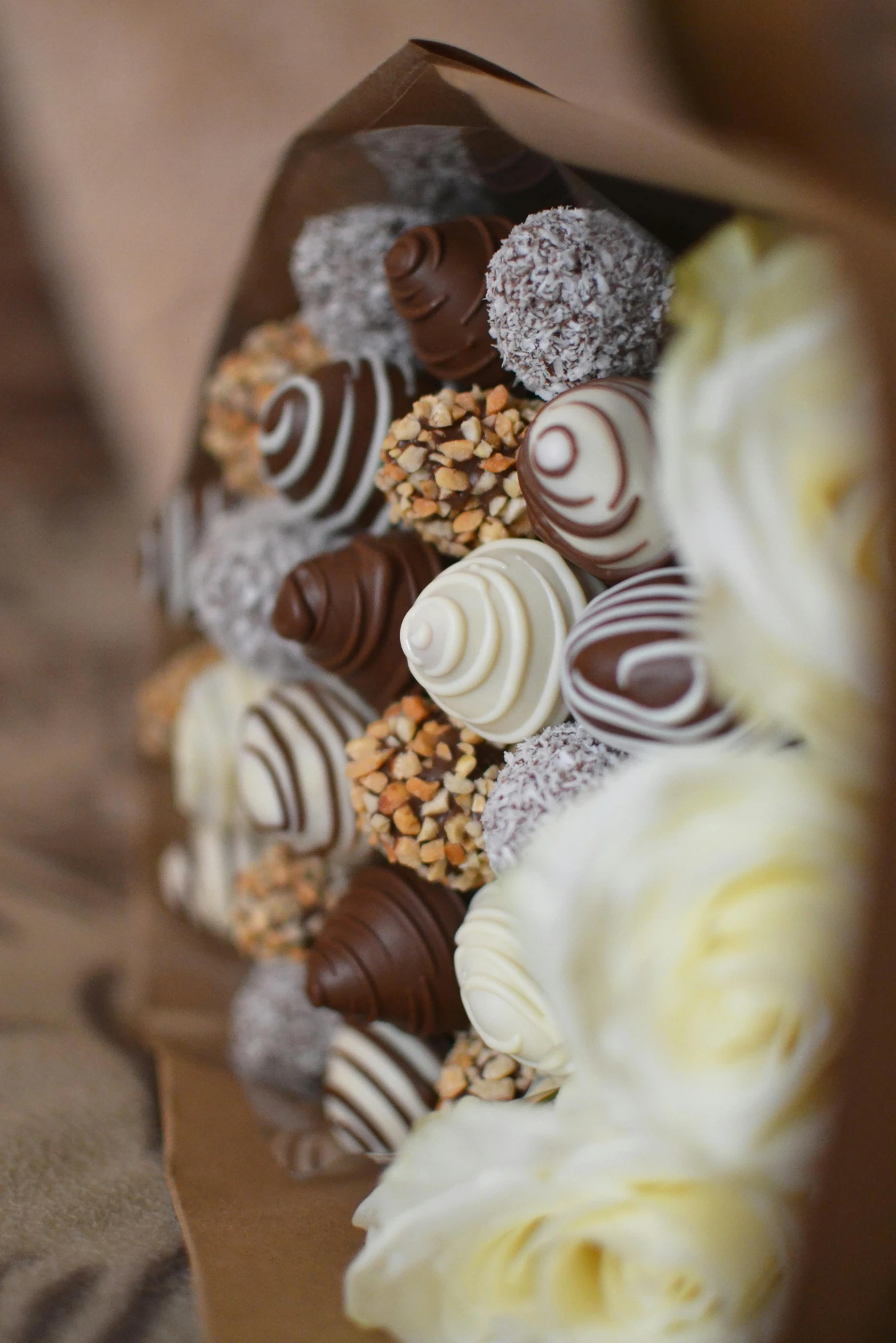 an assortment of chocolates on top of white flower petals