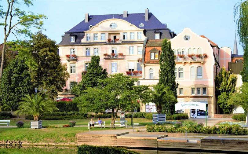 a large old mansion is next to the water