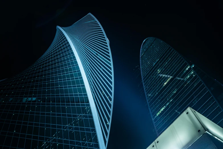 two buildings standing up high in the dark