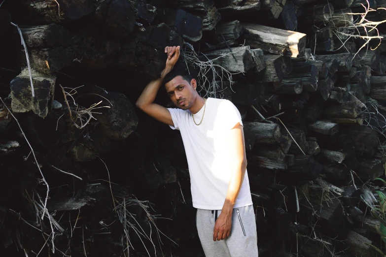 a man is holding his arms up near a pile of rocks