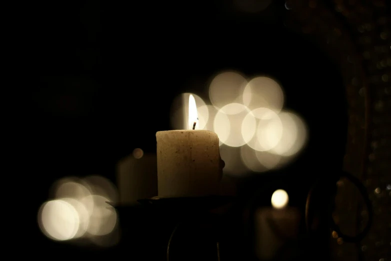 an candle sitting on a table by some lights