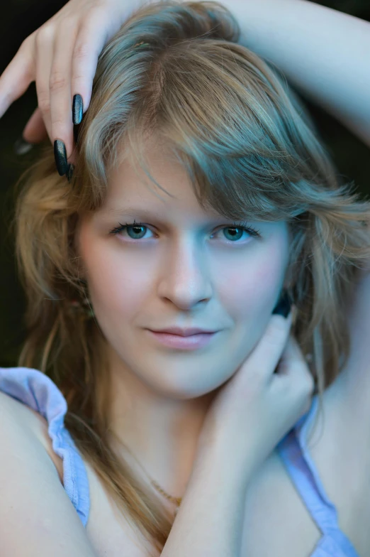 young woman in dress posing while holding her head