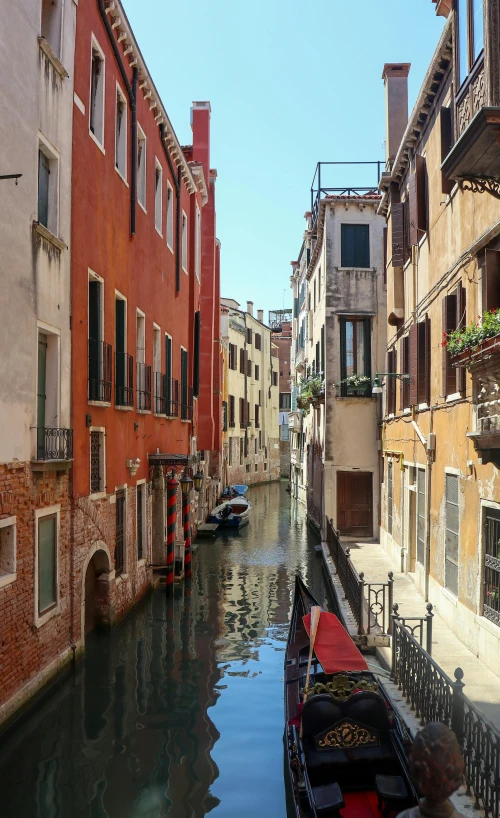 a boat is parked along a narrow canal between buildings