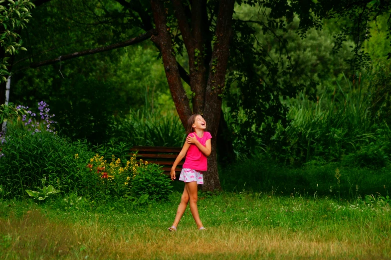 a little girl walking through a green field