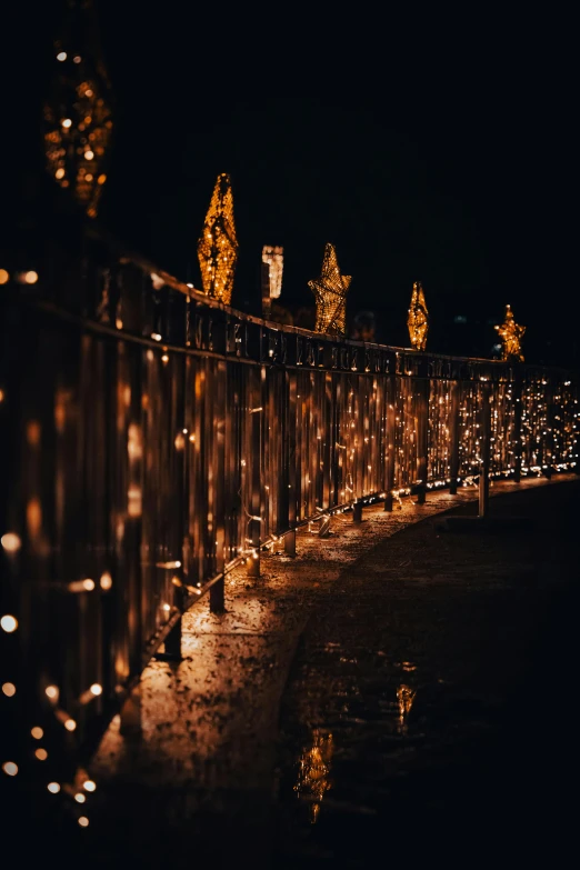 a view over a wooden fence with lights on it