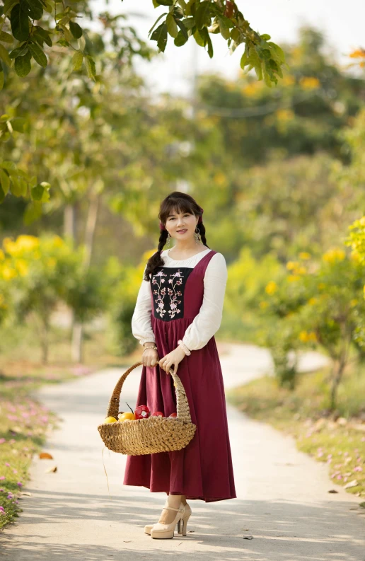 a girl in a red and white dress with a basket