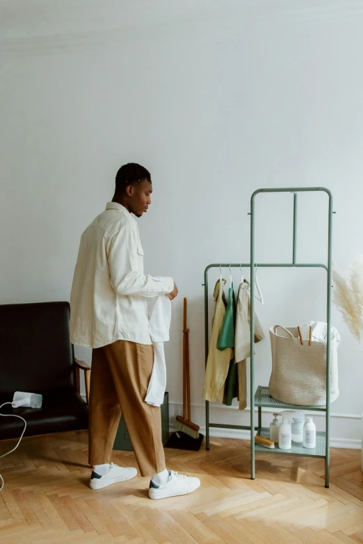 a man in a white sweater is standing in a living room