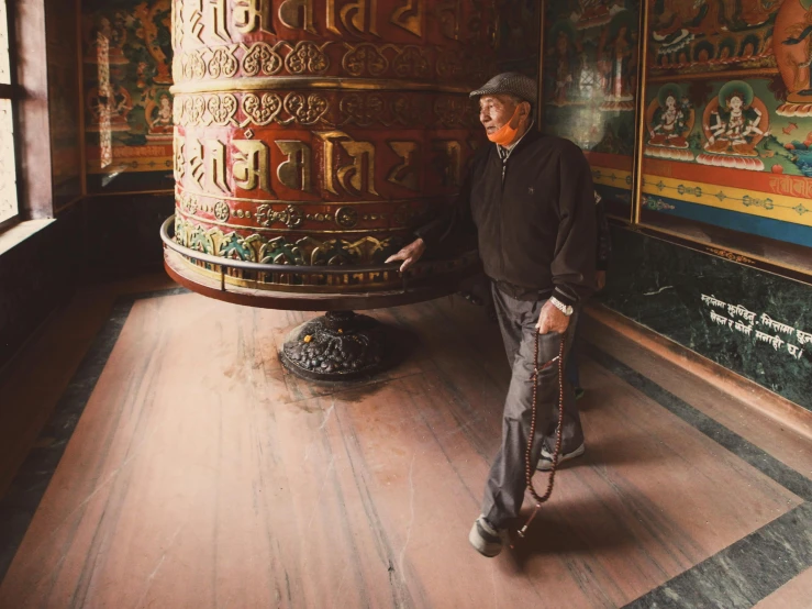 an older man is leaning against the wall with his cane